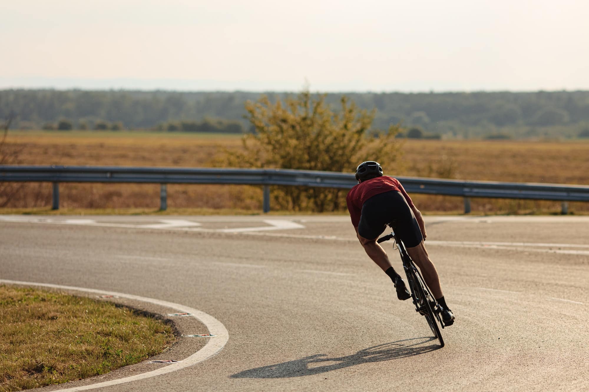 Young sportsman cycling with high speed on road